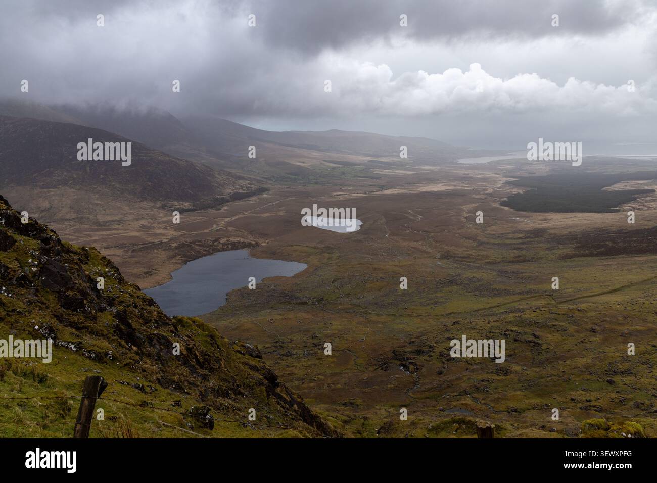 Vista panoramica dal Conor Pass sotto un suggestivo cielo nuvoloso, contea di Kerry, Irlanda Foto Stock