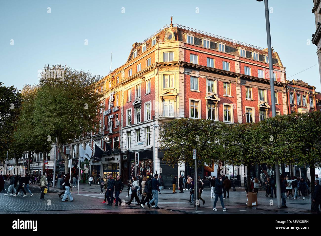Edificio storico in mattoni rossi e pedoni su O'Connell Street a Dublino al tramonto Foto Stock