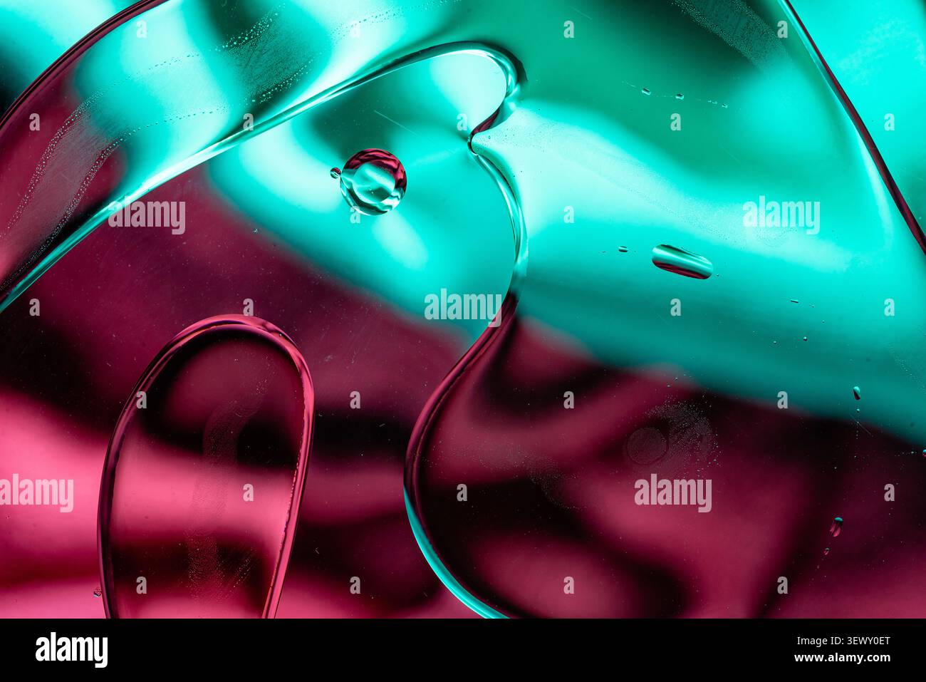 Vista macro dello sfondo verde neon lucido e delle onde liquide magenta Foto Stock