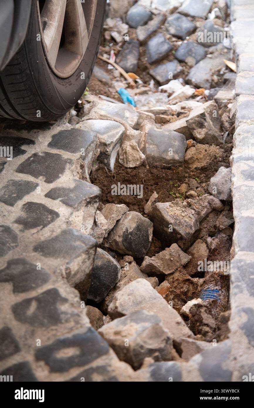 Marciapiede crollato e detriti ostacolano significativamente le operazioni logistiche cittadine Foto Stock