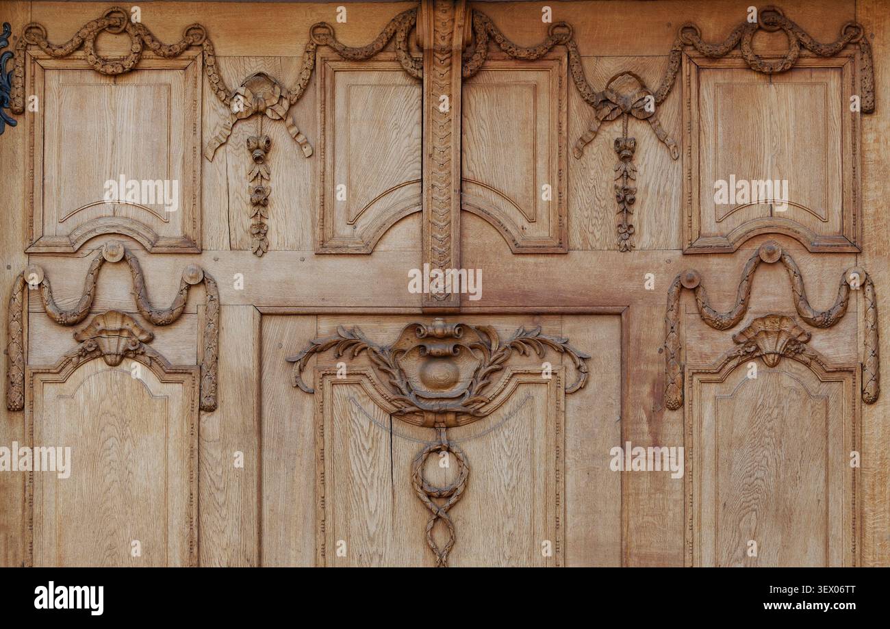 Vista dettagliata di intagli ornamentali in legno e decorazioni a rilievo su una porta antica in legno Foto Stock