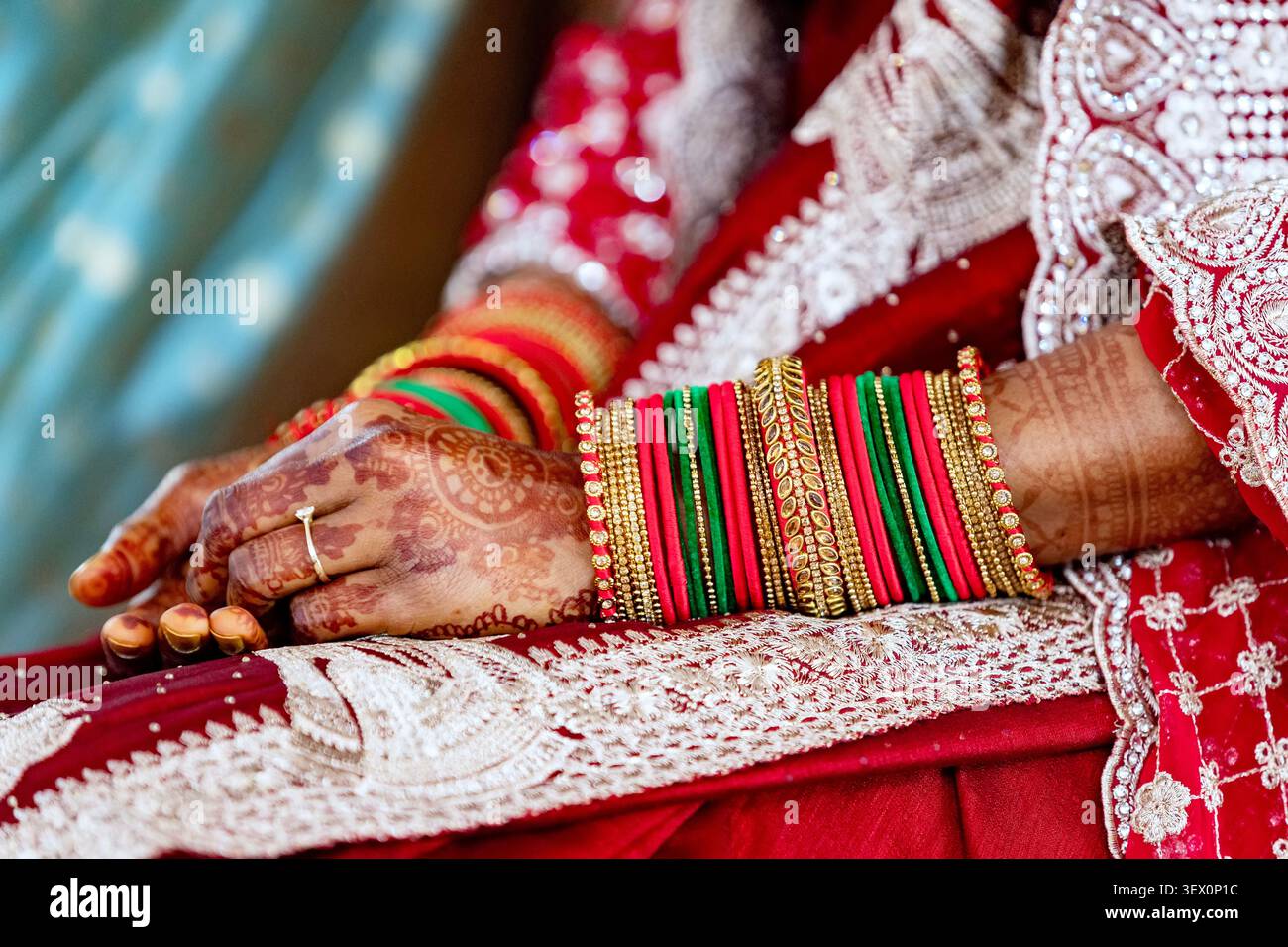 Le tradizionali mani della sposa indiana adornate con henné e bracciali colorati Foto Stock