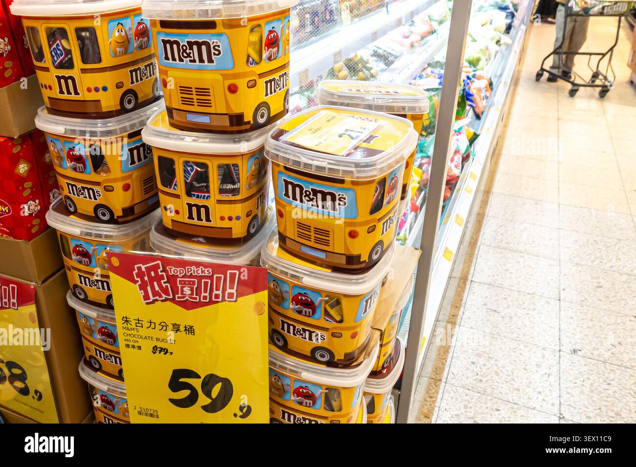 Secchi di cioccolato M&M's con un design distintivo di autobus scolastico giallo, supermercato Wellcome di Hong Kong Foto Stock