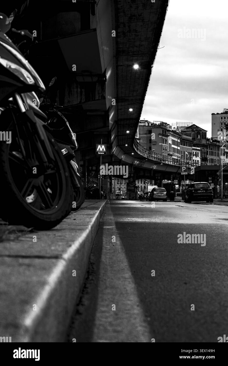 Una foto di una città con una strada e moto al crepuscolo, Genova, Italia Foto Stock