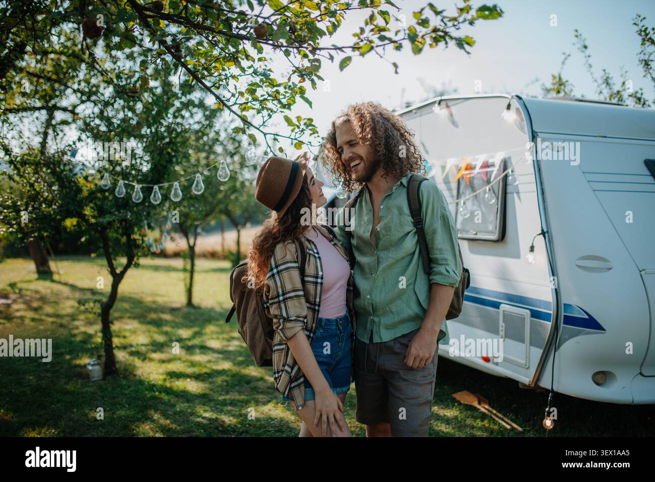Una giovane coppia è in campeggio nella natura. Viaggi in caravan a basso costo. Foto Stock