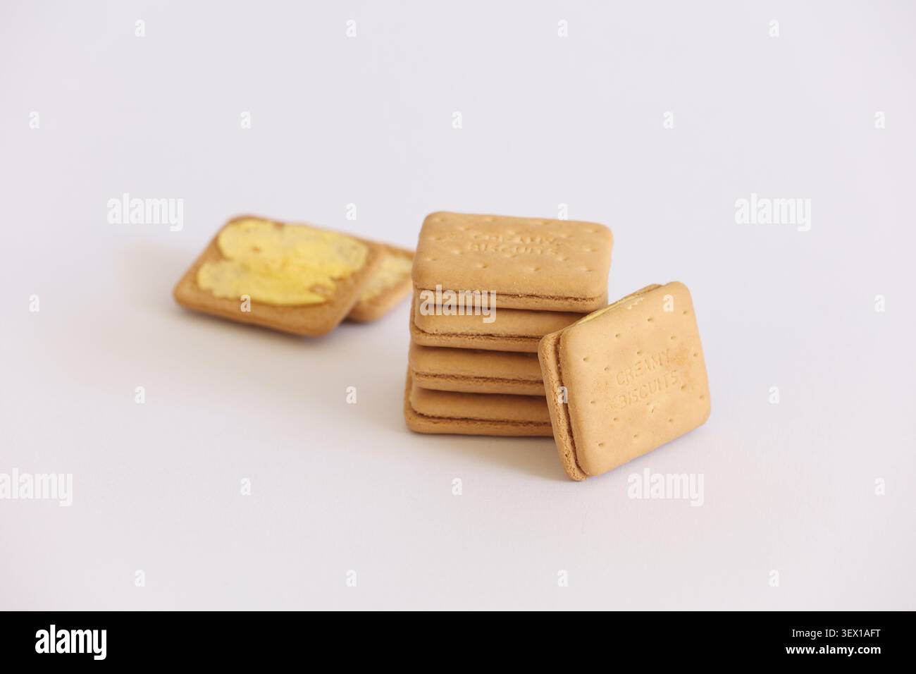 Pila di biscotti con crema e biscotti al burro su sfondo bianco - primi piani di snack Foto Stock