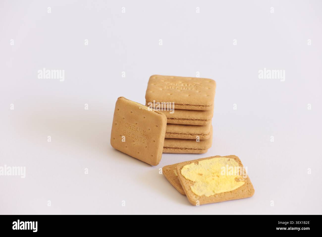 Biscotti alla panna Impastare con spalmazione di burro su sfondo bianco — biscotti sandwich snack per il tè Foto Stock