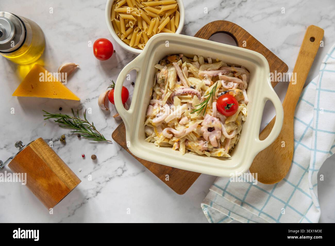 Saporita penne fatte in casa con frutti di mare in salsa cremosa al formaggio su un ripiano in marmo. Sfondo piatto della vista superiore. Foto Stock