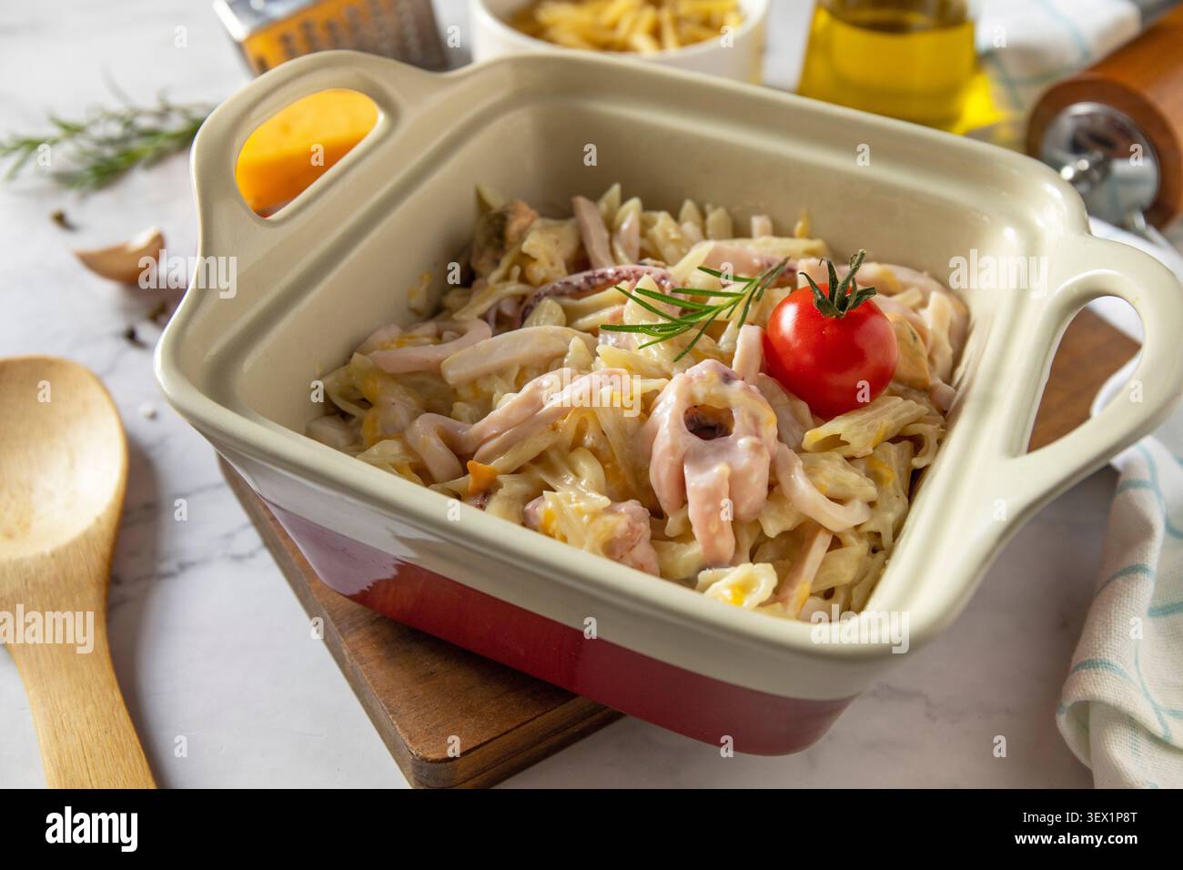Saporita penne fatte in casa con frutti di mare in salsa cremosa al formaggio su un ripiano in marmo. Foto Stock