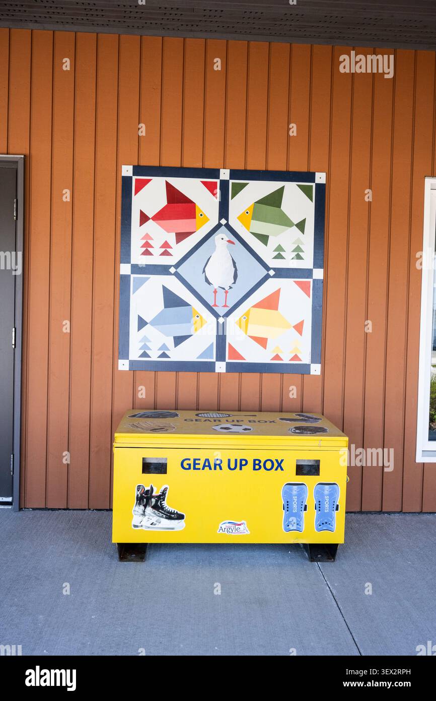 Colorato murale di pesci che ricorda una trapunta e una scatola di equipaggiamento giallo presso gli uffici del comune di Argyle sulla NS 308 a Tusket, nuova Scozia, Canada Foto Stock