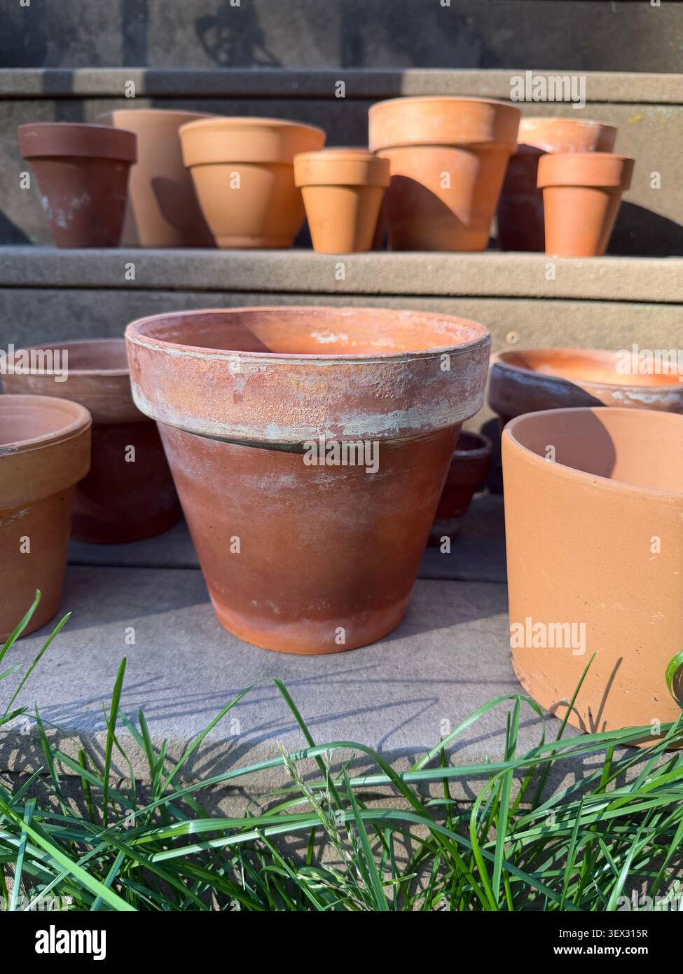Vasi di terracotta con depositi minerali disposti su gradini esterni. Foto Stock