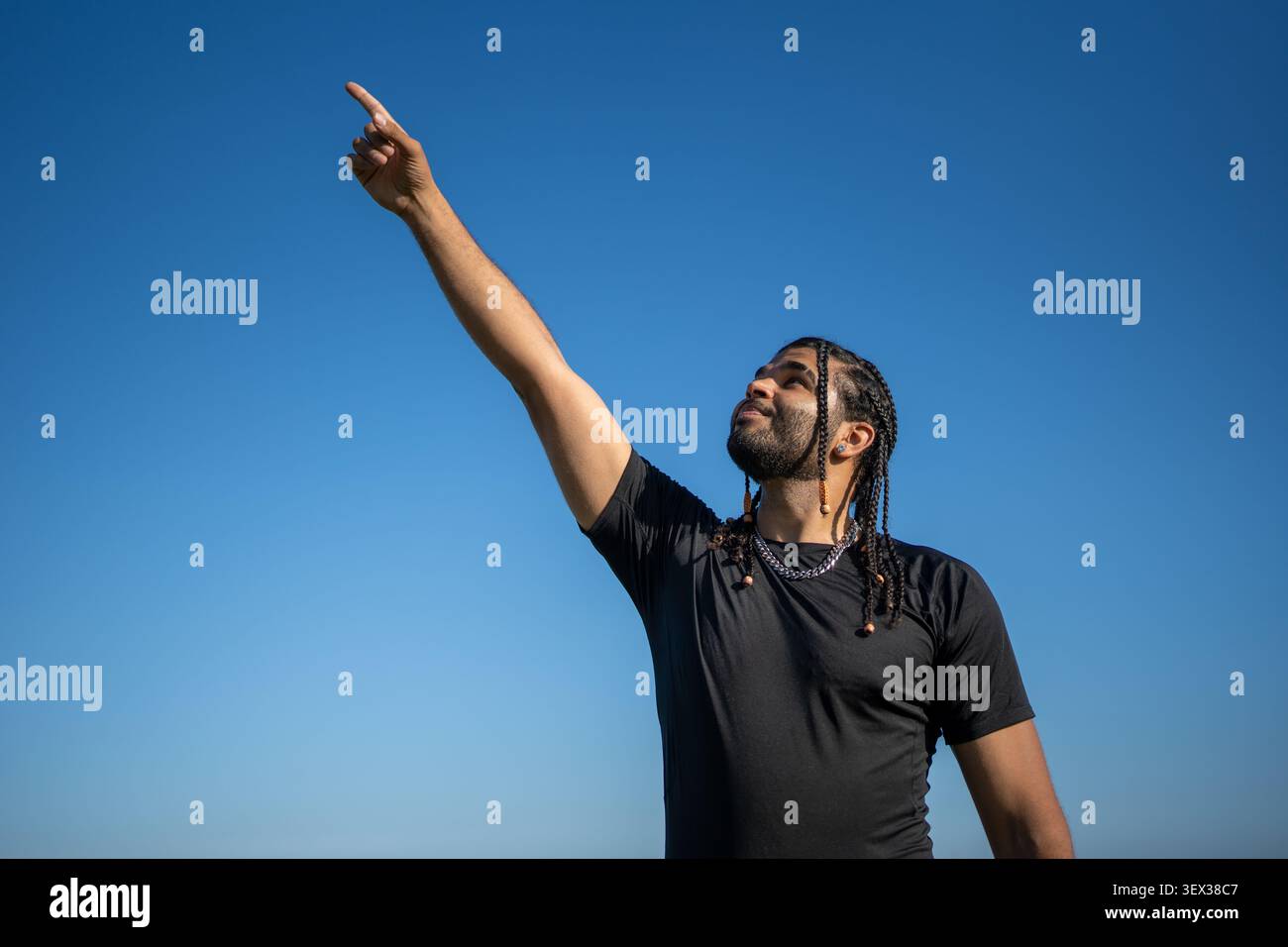 Uomo che punta il dito verso il cielo fissando obiettivi e aspirazioni Foto Stock