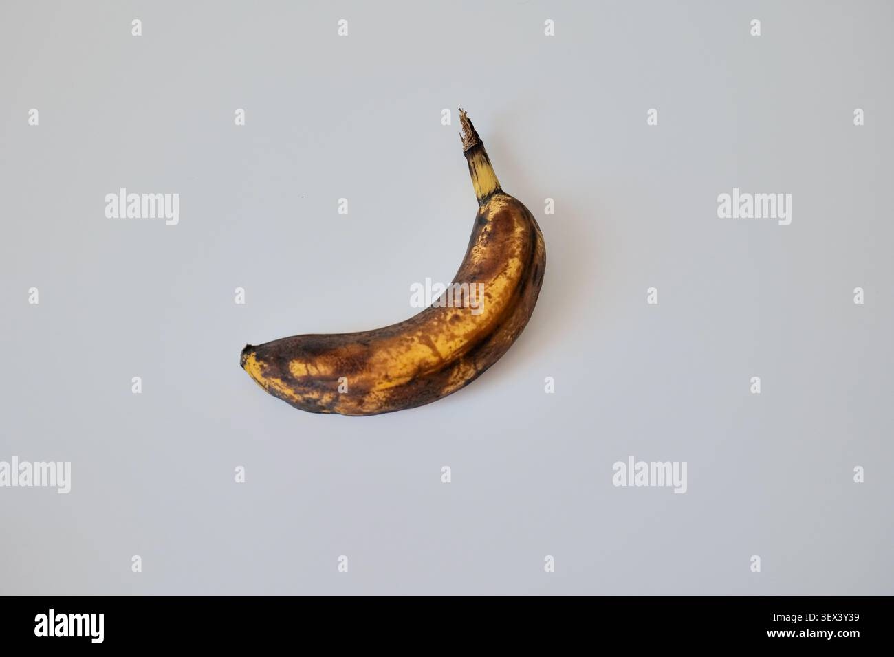 Banana troppo matura con macchie marroni che mostrano invecchiamento e decadimento Foto Stock