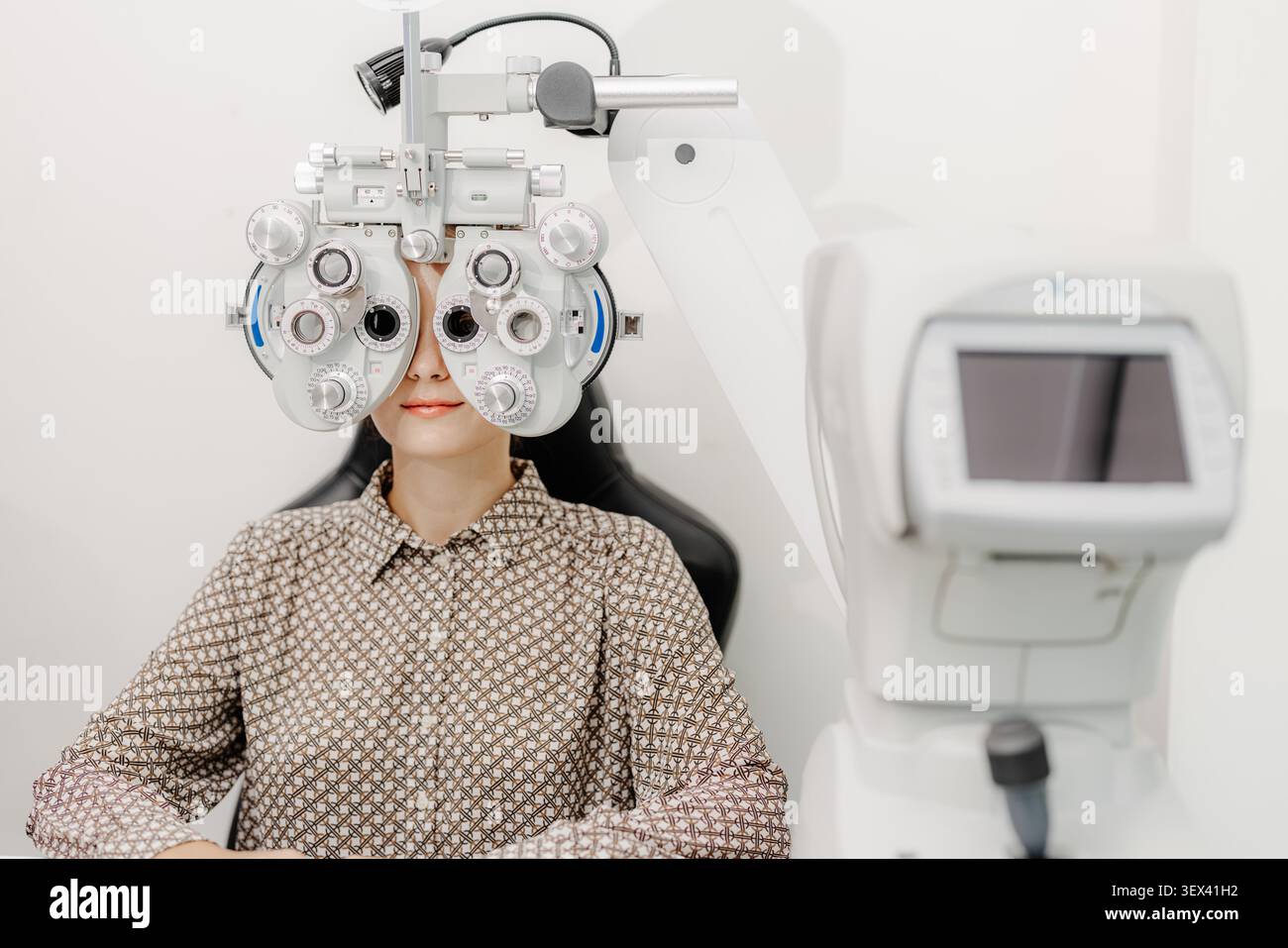 Optometrista che esegue l'esame oculistico con il phoropter, procedura di test di visione, servizio di cura degli occhi, clinica di oftalmologia, Asses di salute oculistica professionale Foto Stock