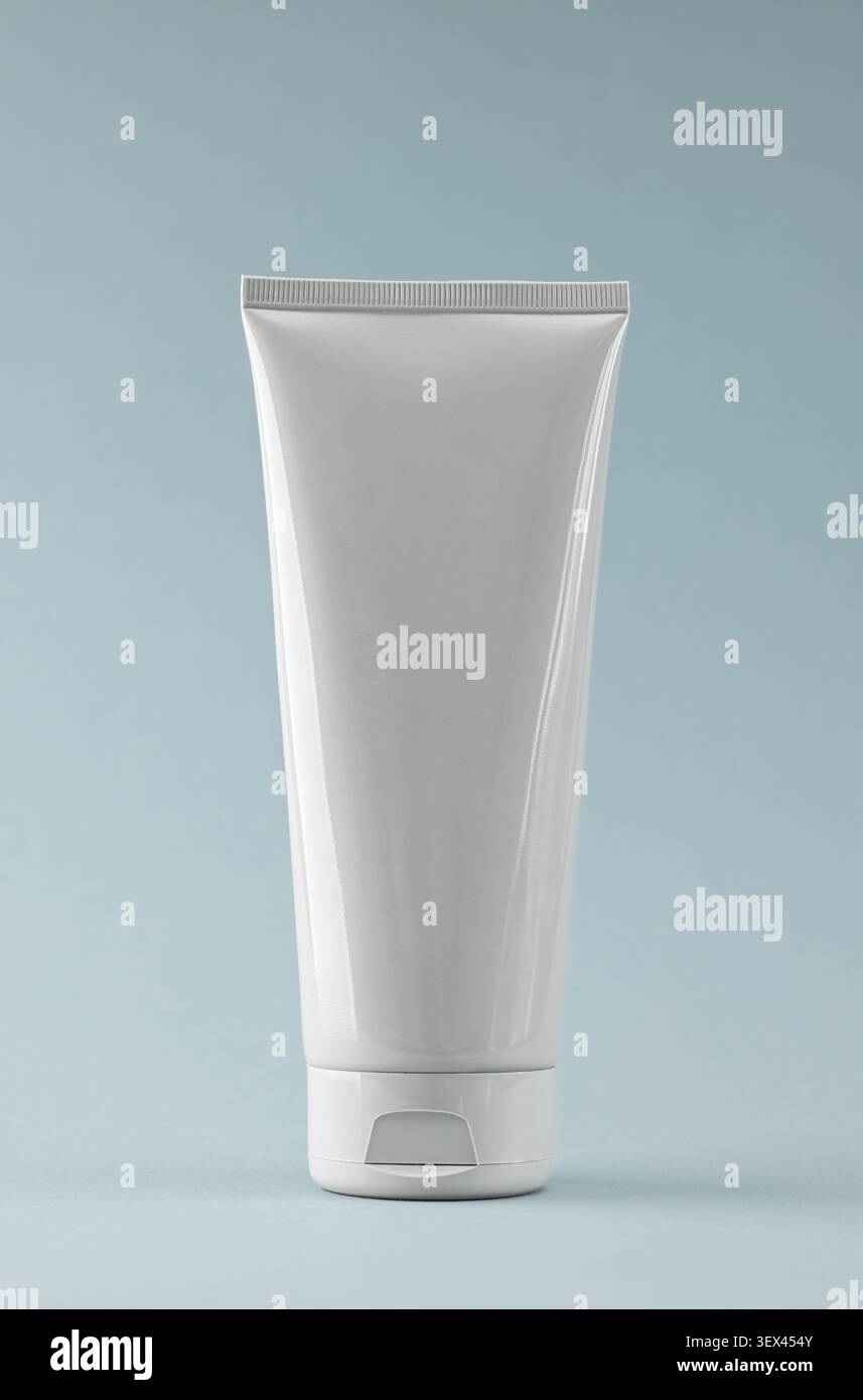 Tubo cosmetico bianco su sfondo blu per Mockup e Design dei prodotti per la cura della pelle Foto Stock