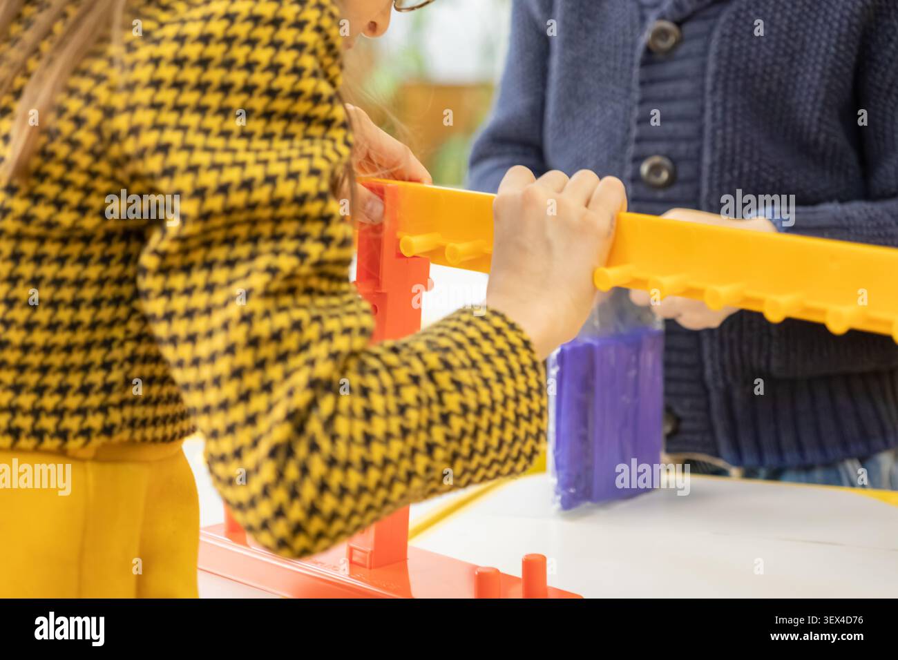 Una visione ravvicinata della costruzione di un giocattolo di plastica insieme cattura lo spirito di cooperazione, sviluppo delle competenze e scoperta giocosa Foto Stock