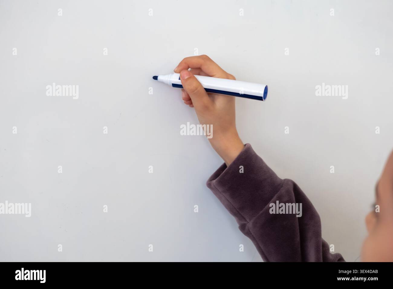 Questa vista ravvicinata di una scrittura a mano con un pennarello blu su una lavagna bianca pulita cattura un momento di apprendimento, ideazione aziendale strategica o interattiva Foto Stock