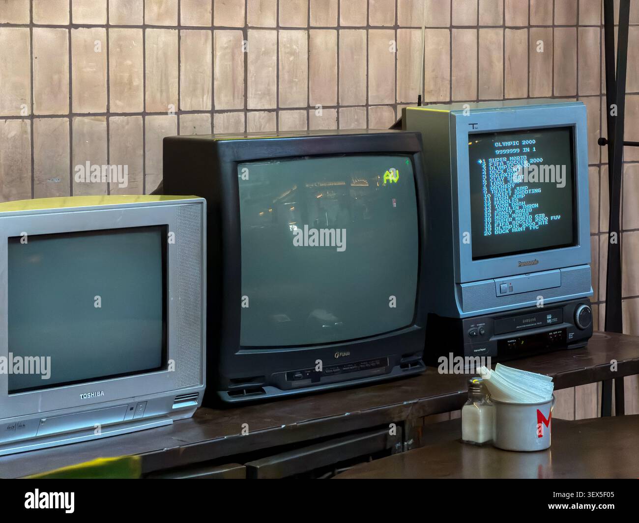 Kiev, Ucraina - 21 marzo 2026: Collezione di vecchi monitor a tubo catodico esposti su un tavolo di un ristorante, che catturano un'estetica classica dal la Foto Stock