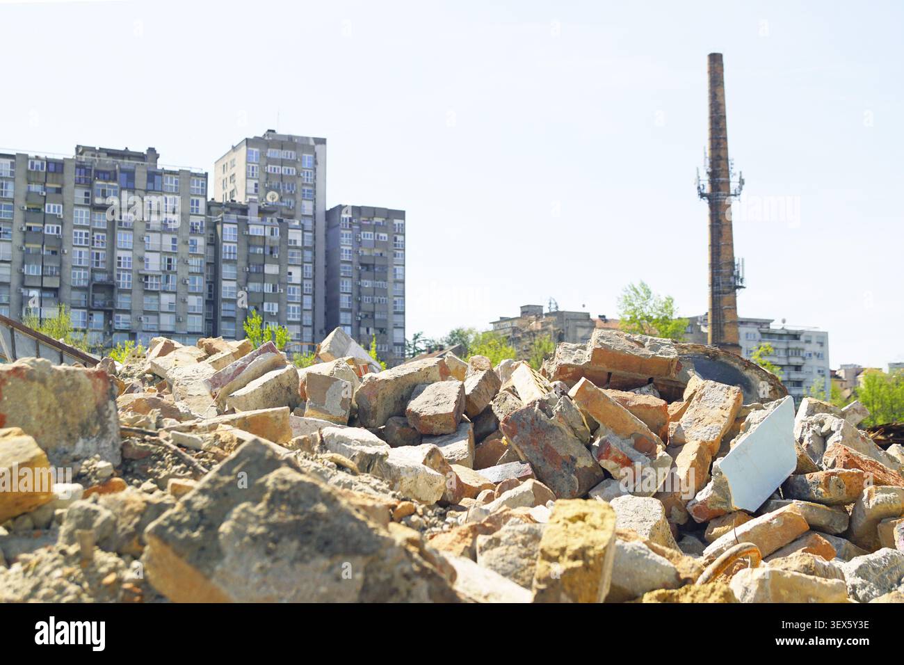 Mattoni rotti e macerie di cemento sparsi su un cantiere di demolizione attivo. Dimostra il riciclo del terreno, il riutilizzo del sito e la pianificazione spaziale strategica. Foto Stock