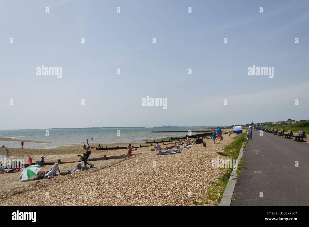 Gente che ama la spiaggia di ciottoli a Lee-)n-Solent nell'Hampshire, Inghilterra. Foto Stock