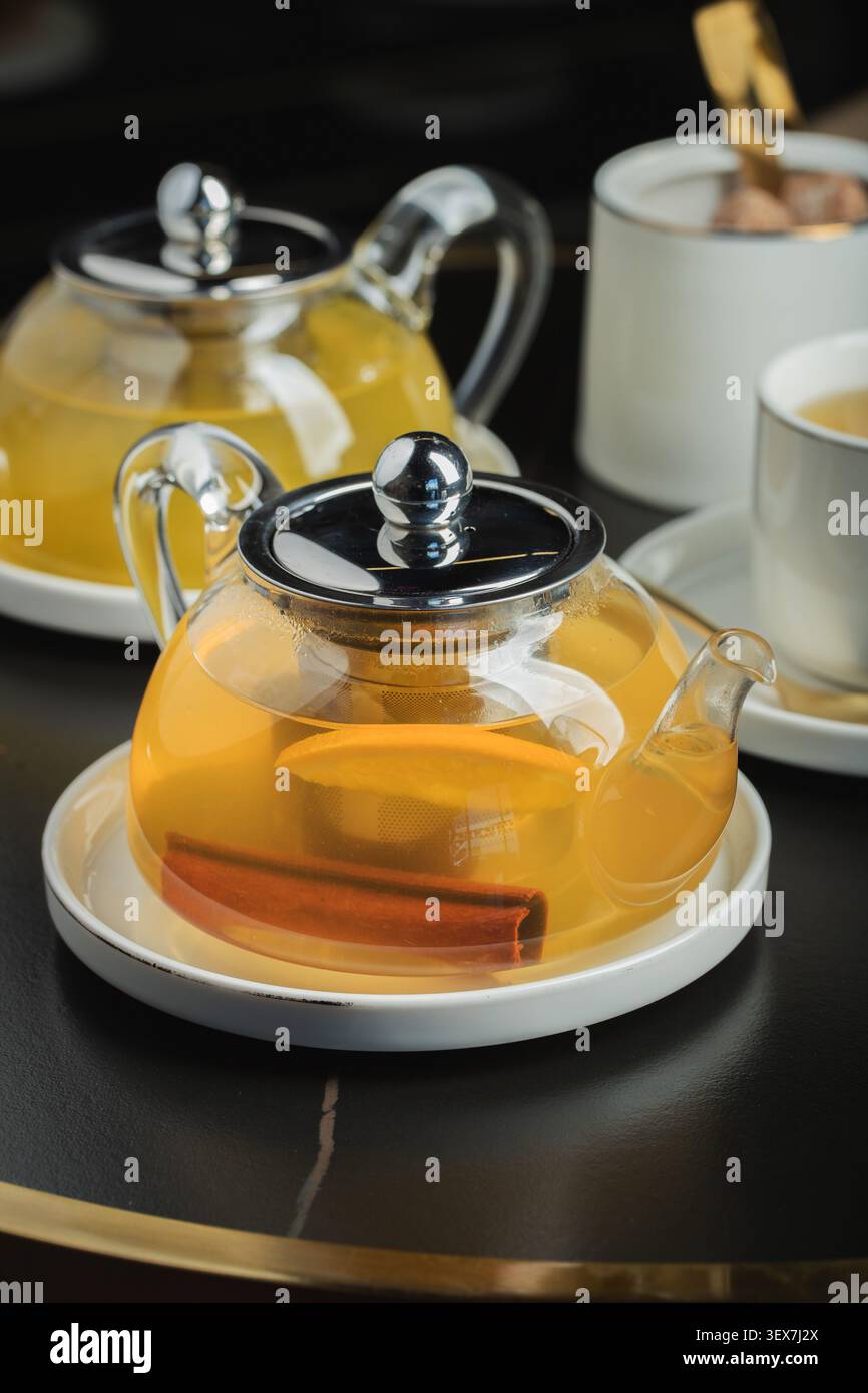 Tè alla frutta con mango e menta in una teiera di vetro sul tavolo Foto Stock