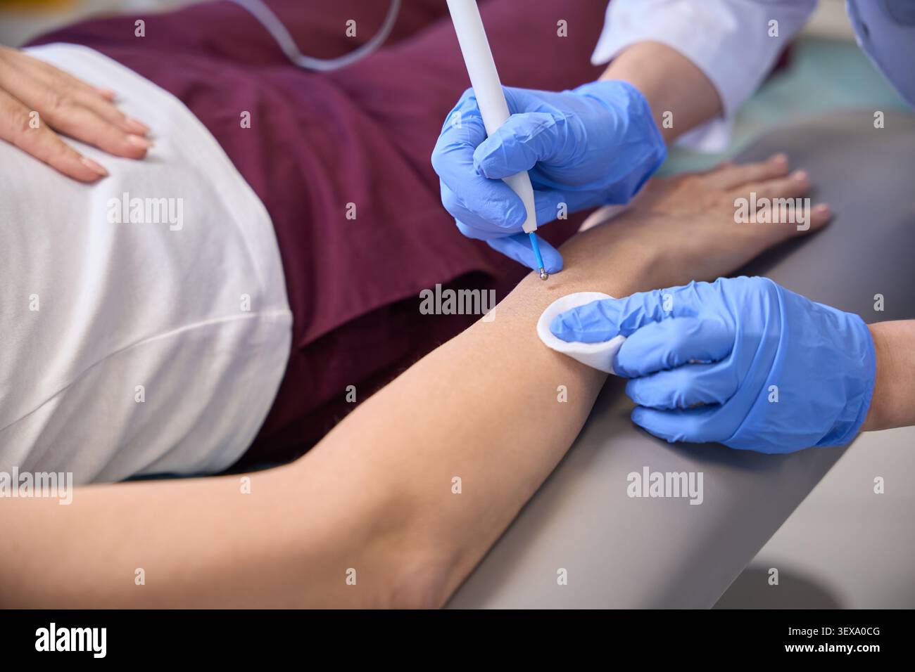 Procedura medica eseguita all'interno su individui che indossano la parte superiore bianca Foto Stock