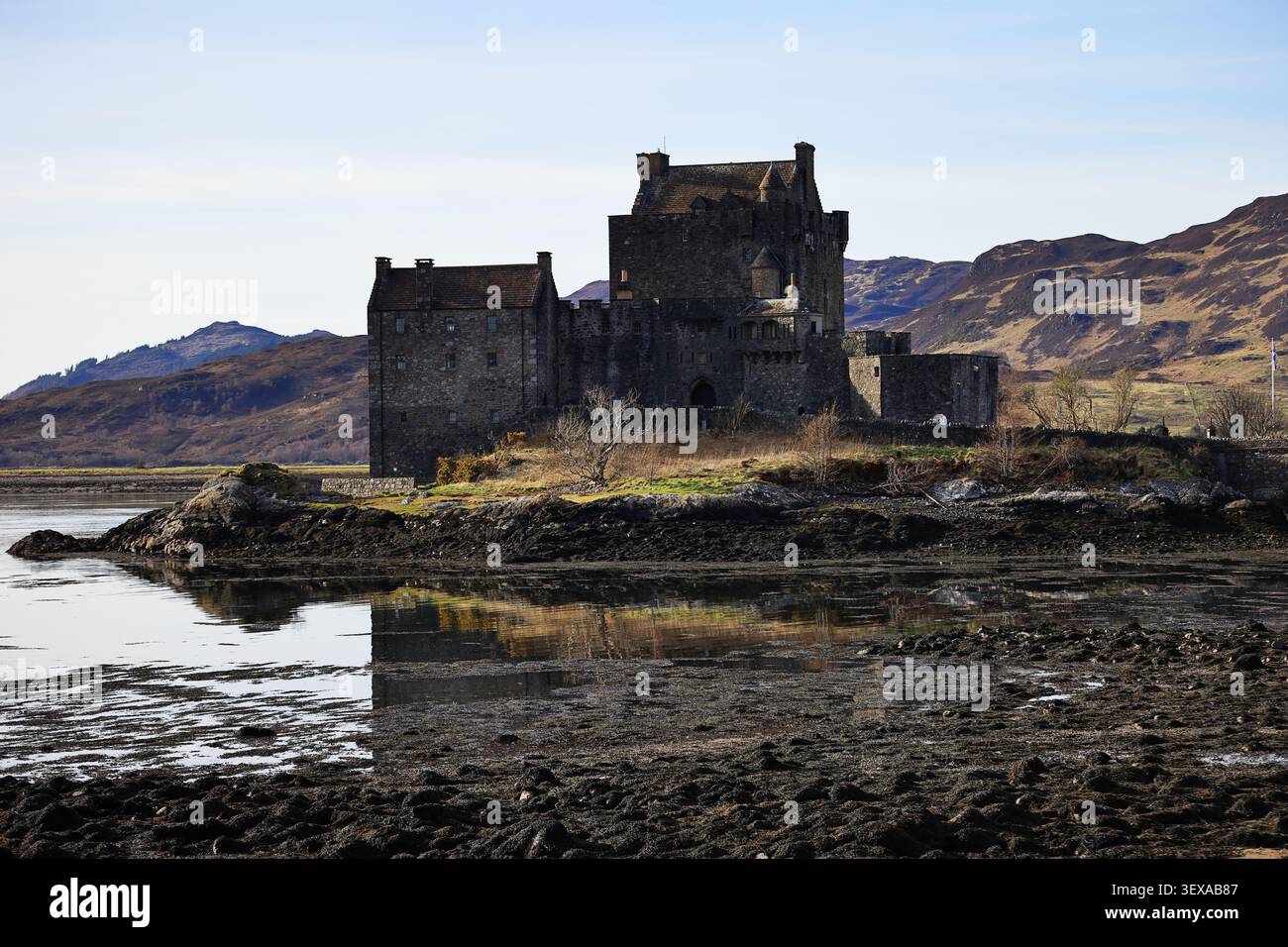 Castello di Eilean Donan e Loch Duich nelle Highlands scozzesi, in Scozia, mostrano il castello e il ponte, lo sfondo delle montagne e la costa rocciosa con acqua blu. Foto Stock