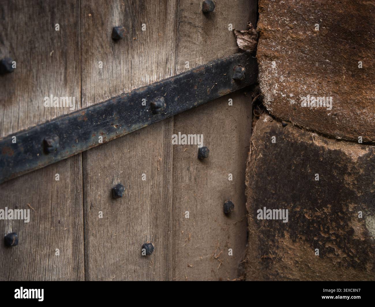 Vecchio edificio medievale con cerniere in ferro per porte in legno Foto Stock