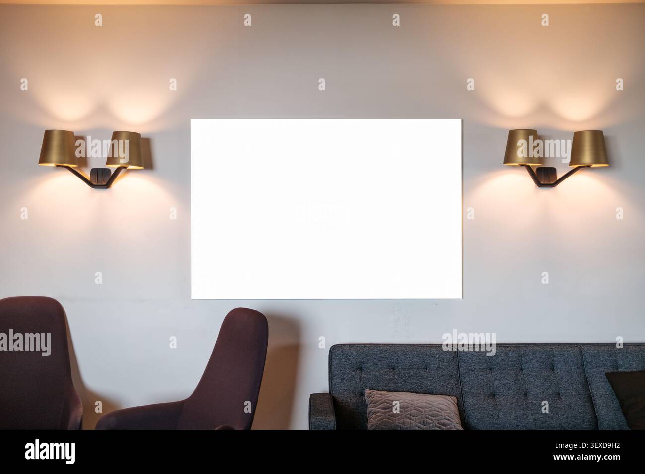 Accogliente spazio lounge scandinavo contemporaneo con cornice bianca, illuminazione a parete in ottone e arredi moderni in un'atmosfera calda Foto Stock