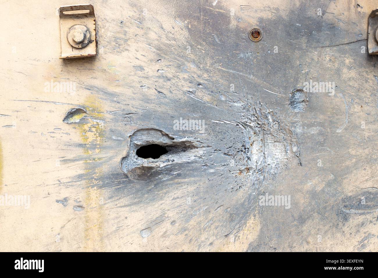 Primo piano di fori proiettili e segni di impatto sulla superficie di un veicolo blindato in metallo. Danni di guerra, tecnologia militare, cicatrici da battaglia. Foto Stock