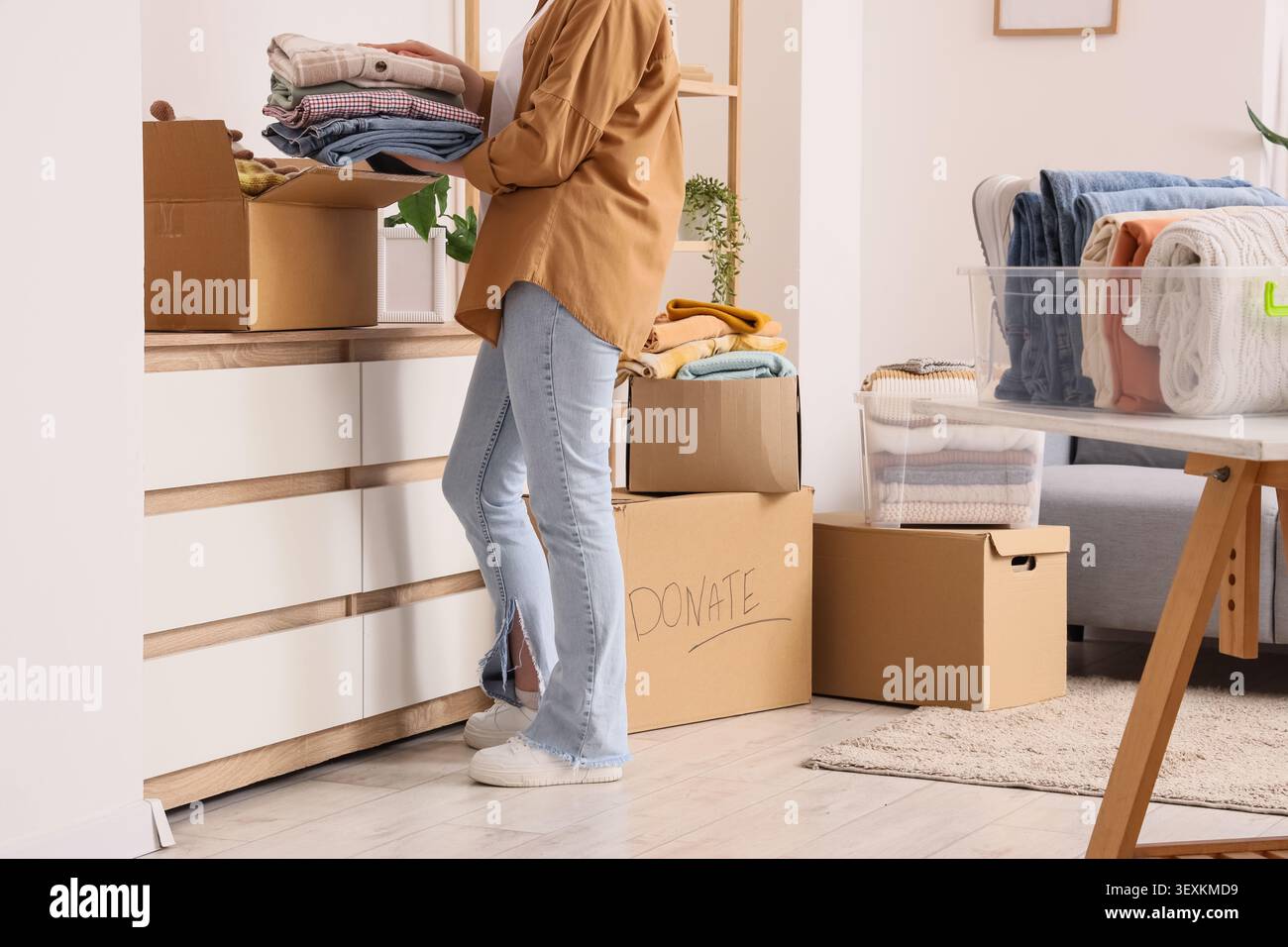 Persona che prepara vestiti per una donazione a casa Foto Stock