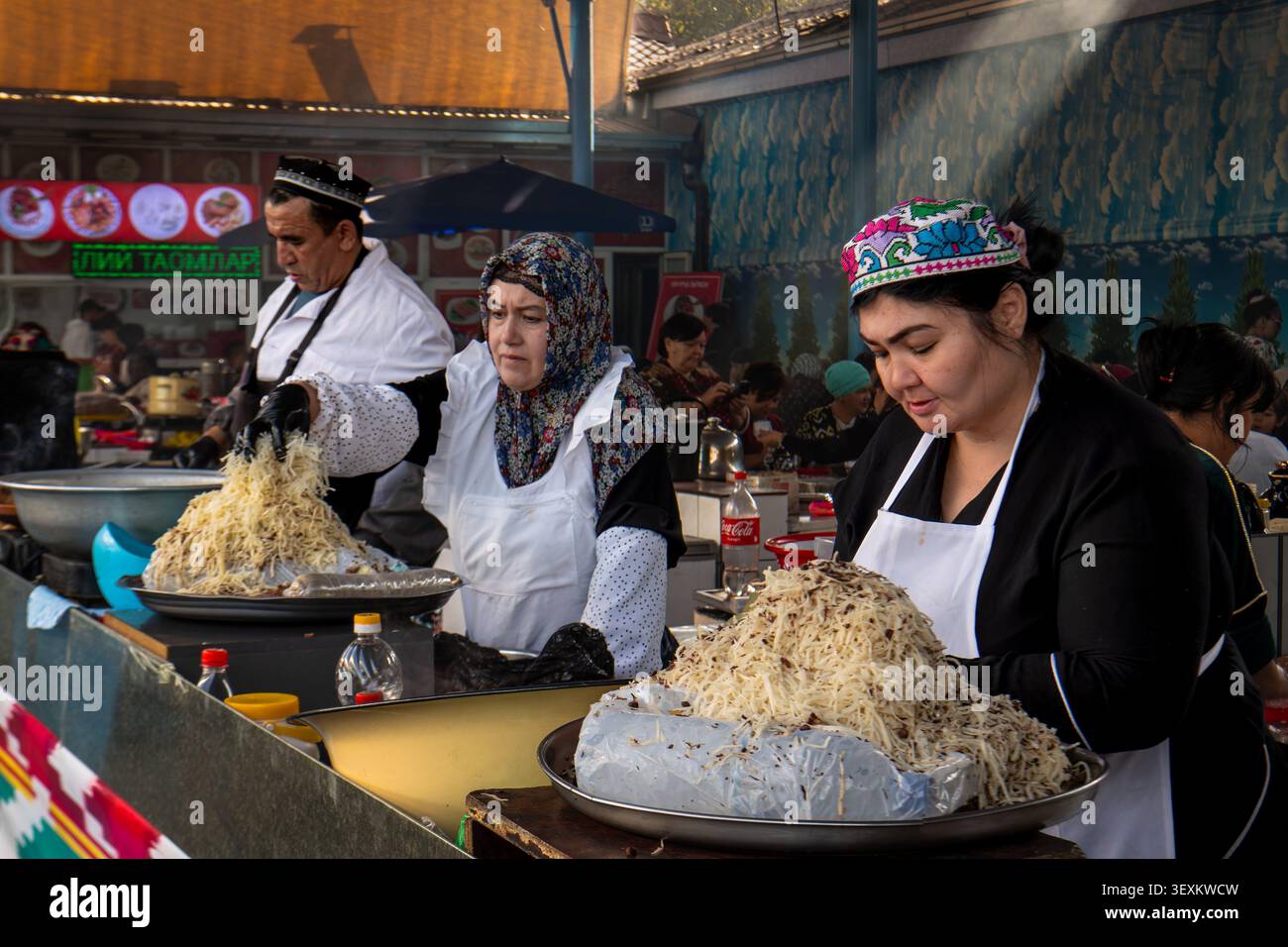 Venditori ambulanti che vendono cibi pronti al consumo presso il mercato coperto "Bazar Chorsu", situato nel centro storico di Tashkent, la capitale dell'Uzbekistan. Foto Stock