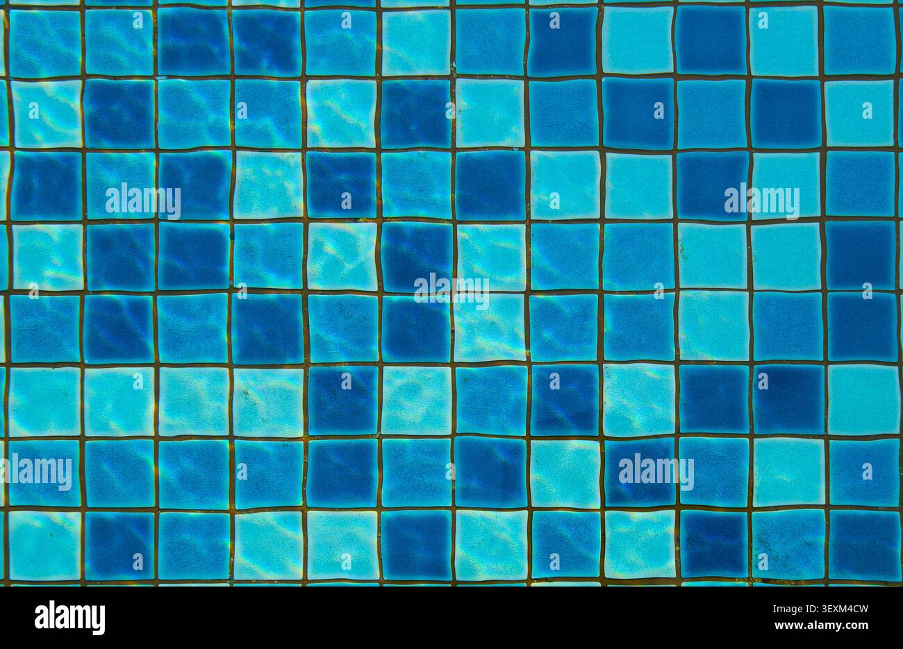 Piastrelle quadrate blu e turchese che creano un motivo a mosaico sottomarino con acqua increspata Foto Stock