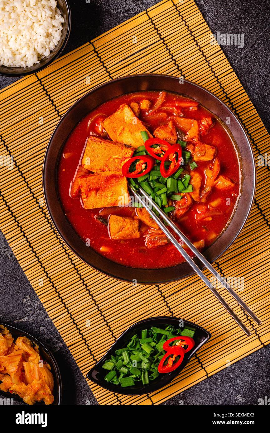 Cibo tradizionale coreano, zuppa piccante di kimchi (tige di kimchi) con maiale e formaggio tofu. Vista dall'alto. Foto Stock
