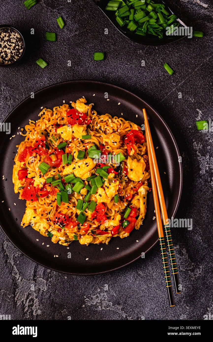 Spaghetti istantanei in stile coreano, Shin Ramyeon con pomodori e uova strapazzate, vista dall'alto. Foto Stock