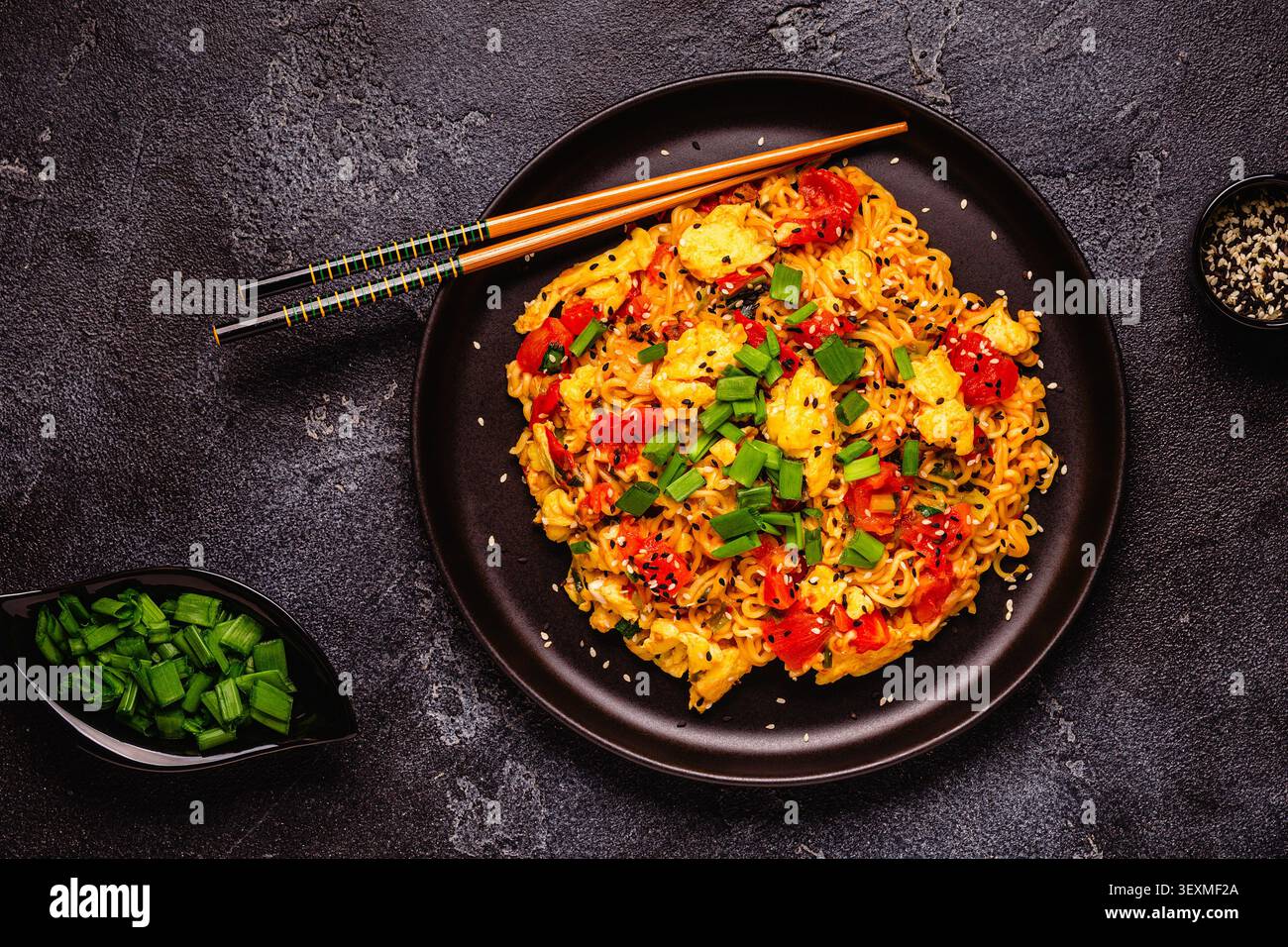 Spaghetti istantanei in stile coreano, Shin Ramyeon con pomodori e uova strapazzate, vista dall'alto. Foto Stock