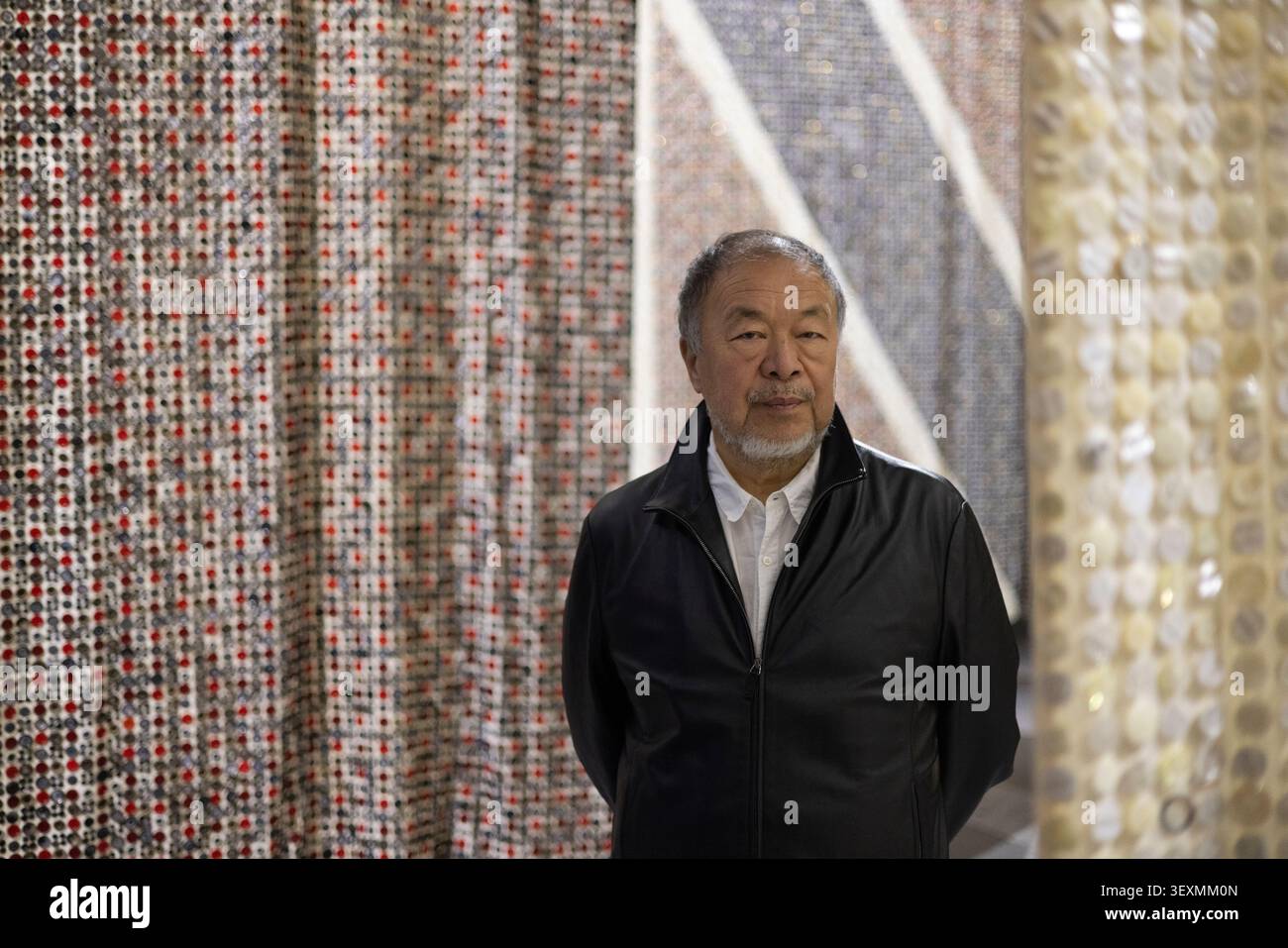 Manchester, Inghilterra, 1 luglio 2026. L'artista e attivista cinese ai Weiwei attraversa ÔButton Up!Õ, la sua nuova mostra monumentale che esplora il commercio, l'impero e lo sfruttamento, in piedi di fronte a otto bandiere della Nation Alliance (fatte di bottoni), agli Aviva Studios di Manchester, in Inghilterra, il luglio 2026. Crediti fotografici: Jeremy Sutton-Hibbert/Alamy Live News. Foto Stock
