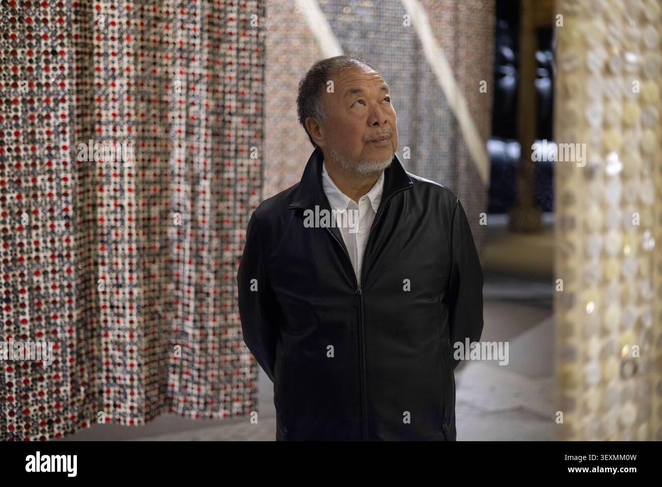 Manchester, Inghilterra, 1 luglio 2026. L'artista e attivista cinese ai Weiwei attraversa ÔButton Up!Õ, la sua nuova mostra monumentale che esplora il commercio, l'impero e lo sfruttamento, in piedi di fronte a otto bandiere della Nation Alliance (fatte di bottoni), agli Aviva Studios di Manchester, in Inghilterra, il luglio 2026. Crediti fotografici: Jeremy Sutton-Hibbert/Alamy Live News. Foto Stock