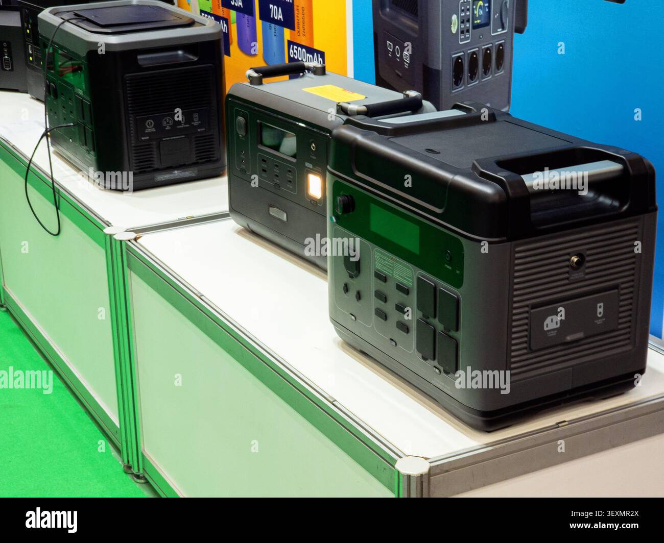 Una collezione di moderne centrali elettriche portatili e generatori solari esposti su un bancone bianco, che mostra varie capacità per l'alimentazione di emergenza AN Foto Stock
