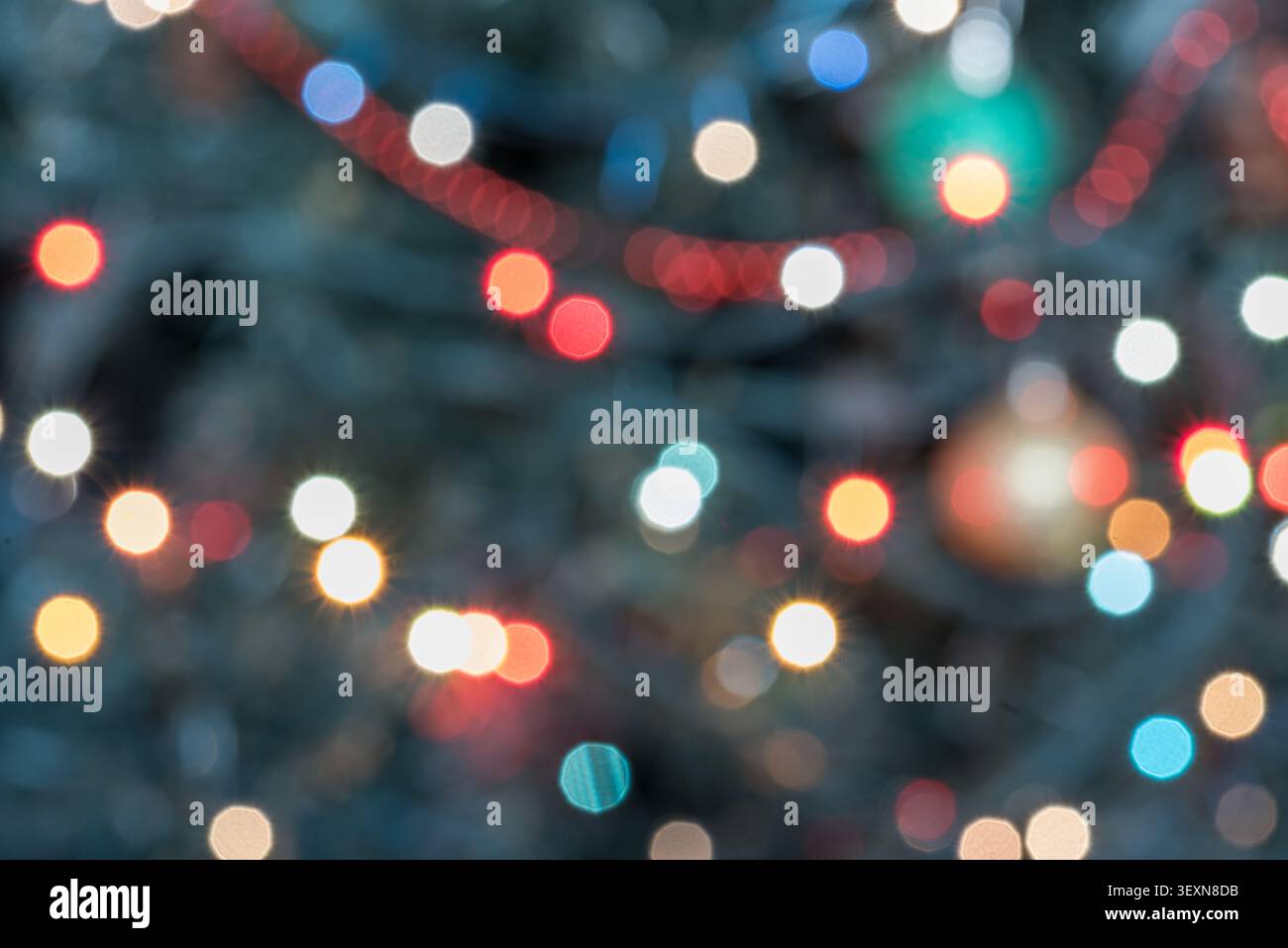 Primo piano, sfondo astratto per le feste con calde luci natalizie che creano un ricco effetto bokeh. La composizione presenta un dorato morbido, Re Foto Stock