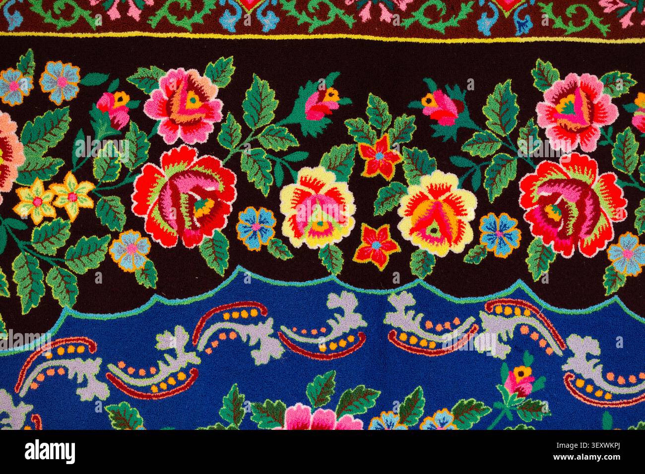Tessuti colorati con intricati motivi floreali in stile slavo su sfondo scuro. Foto Stock