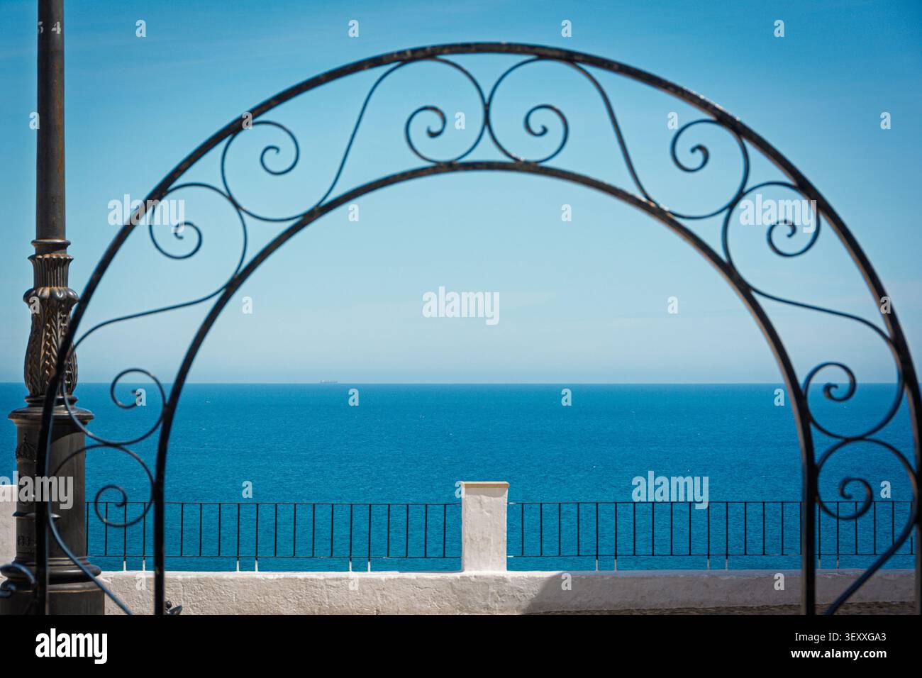 Arco in ferro battuto che incornicia l'orizzonte del Mar Mediterraneo ad Altea, Alicante Foto Stock