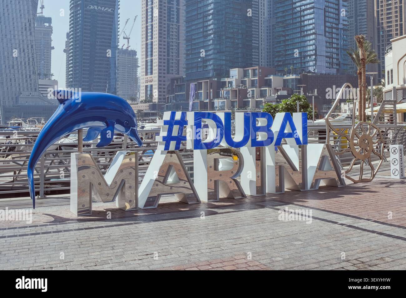 Dubai, Emirati Arabi Uniti, 20.06.2026: Logo ufficiale Dubai Marina, cartello di installazione artistica con skyline di lusso e porto per yacht. Foto Stock