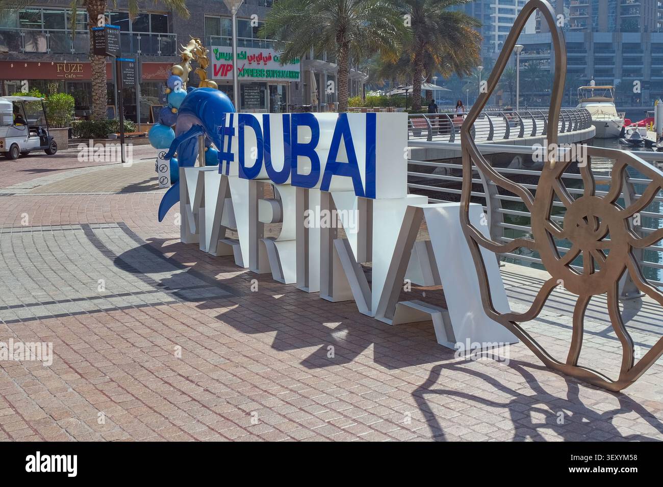 Dubai, Emirati Arabi Uniti, 20.06.2026: Logo ufficiale Dubai Marina, cartello di installazione artistica con skyline di lusso e porto per yacht. Foto Stock