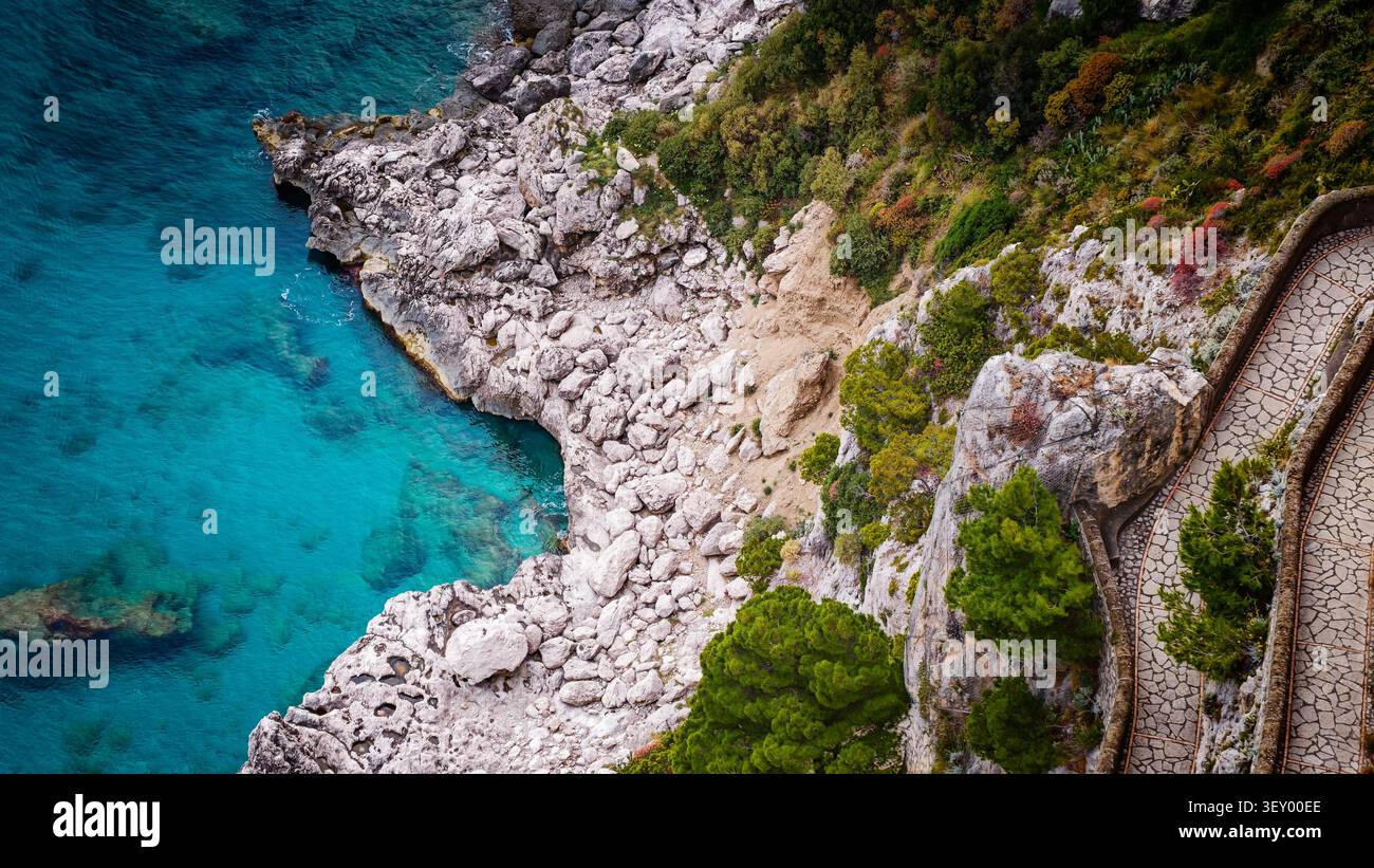 Veduta aerea in droni di via Krupp, le tortuose scale con il paesaggio mozzafiato sull'isola di Capri, in Italia, le scogliere spettacolari, il mare turchese e l'iconica isola Foto Stock
