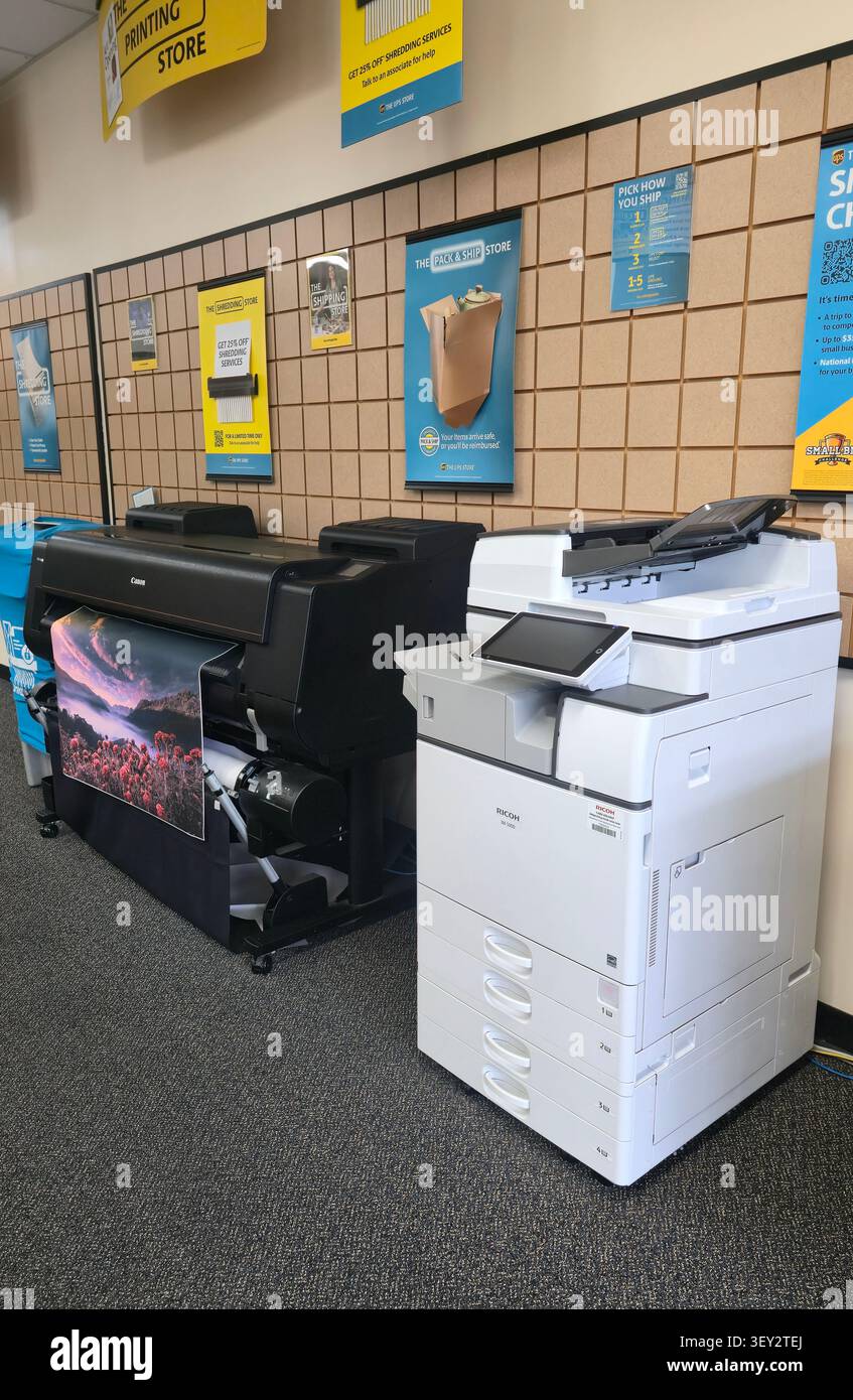 Stampante e fotocopiatrice di grande formato in un'area di servizio di stampa e spedizione di UPS Store - Immagine stock catturata con smartphone