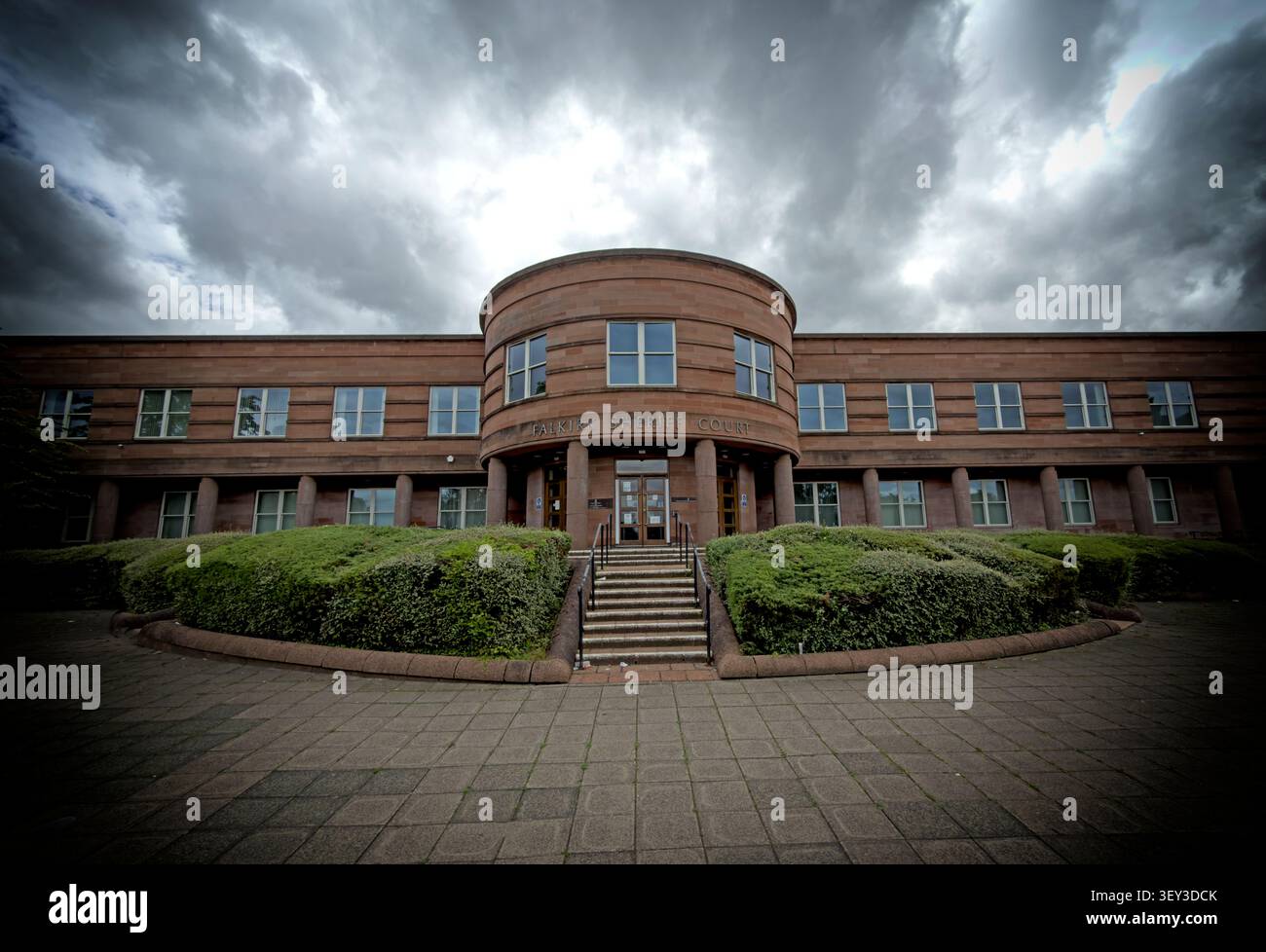 Vista esterna ad angolo ampio del Falkirk Sheriff Court e del Justice of the Peace Court, Camelon, Scozia, sotto un drammatico cielo nuvoloso Foto Stock