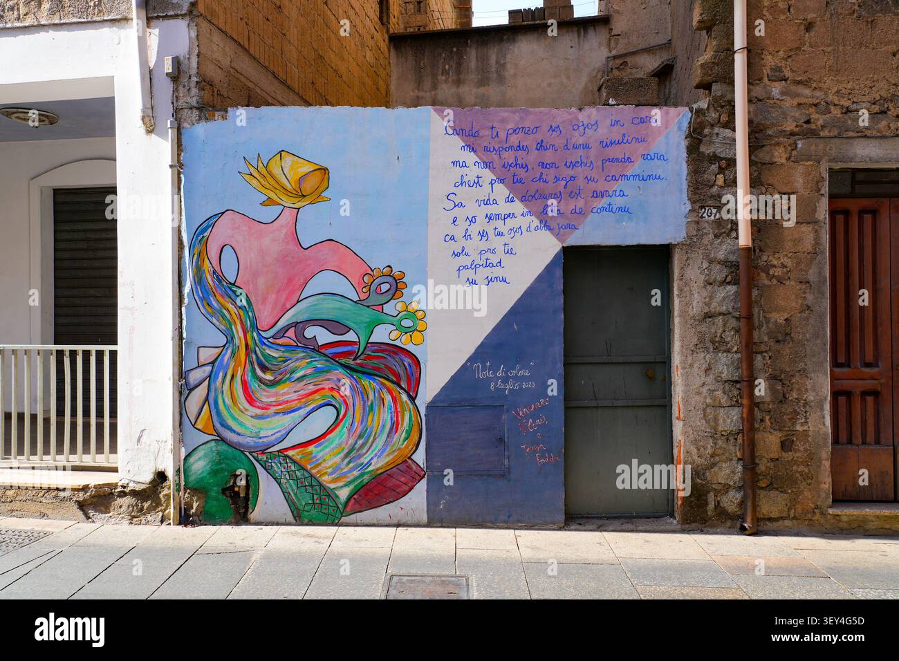 Murale di strada colorato stilizzato con testo poetico su un muro di casa a Orgosolo, Barbagia, Sardegna, Italia Foto Stock