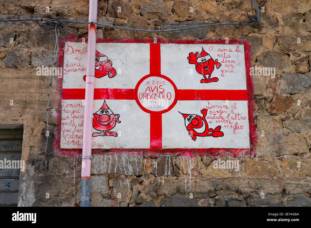 Murale dipinto per l'associazione AVIS Orgosolo donazione di sangue su un muro rustico in pietra a Orgosolo, Sardegna, Italia Foto Stock