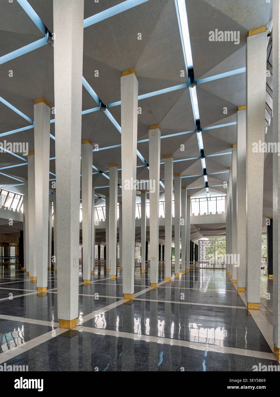Architettura moderna della sala di preghiera principale all'interno della Moschea Nazionale Masjid Negara, caratterizzata da soffitti geometrici e colonne bianche a Kuala Lumpur, Malesia Foto Stock